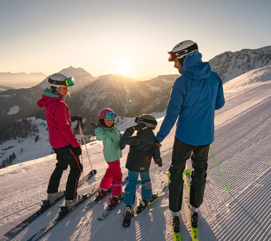 Familie beim Skifahren auf der Skipiste